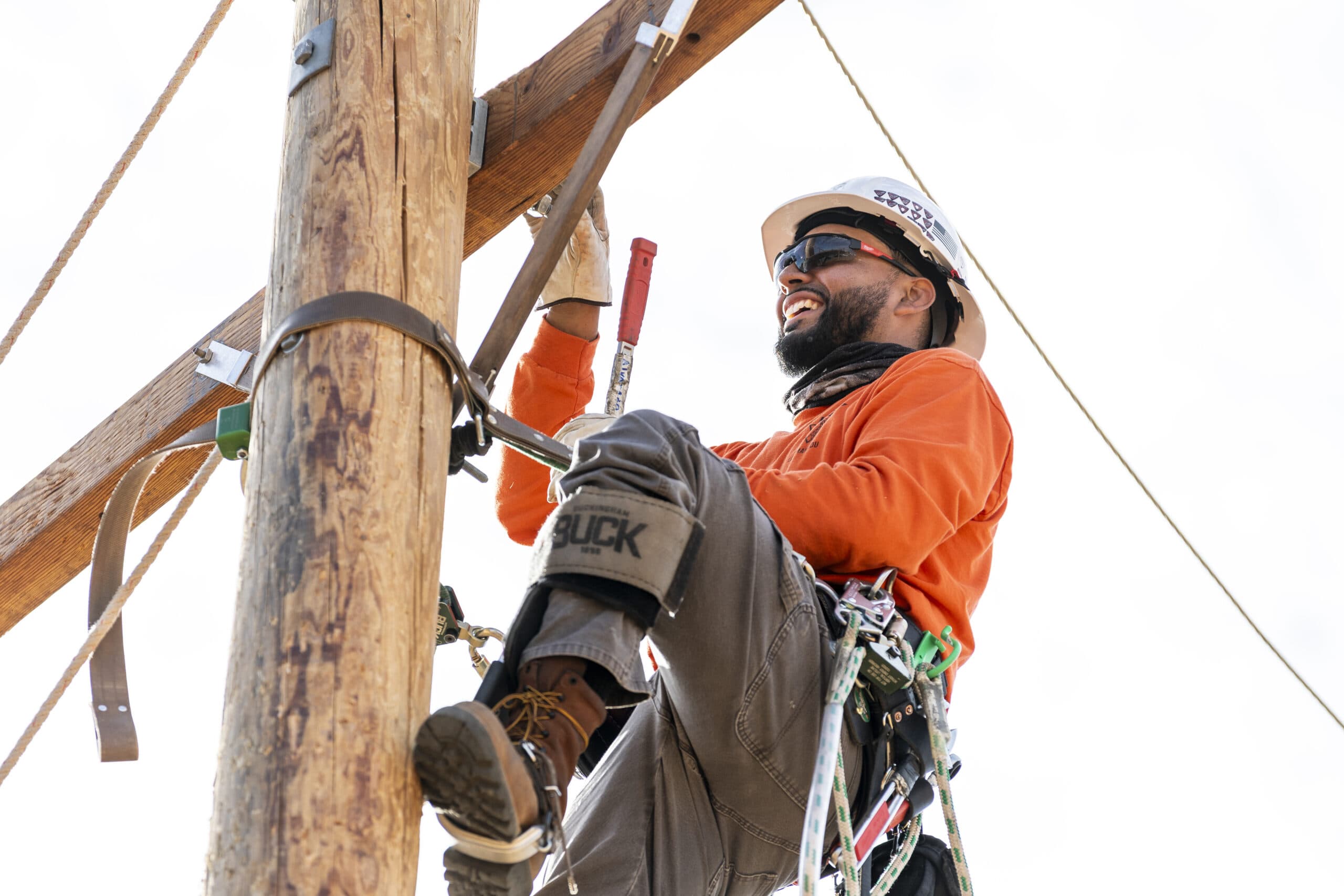 NLC student smiling while working on a pole